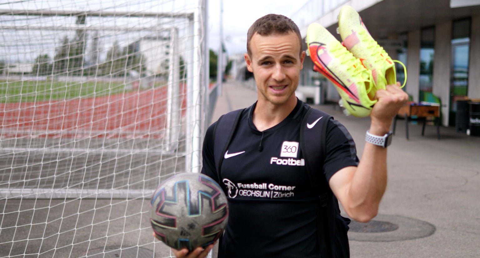 Nic von 360Football vor dem Platz mit Ball und Fussballschuhen in der Hand.